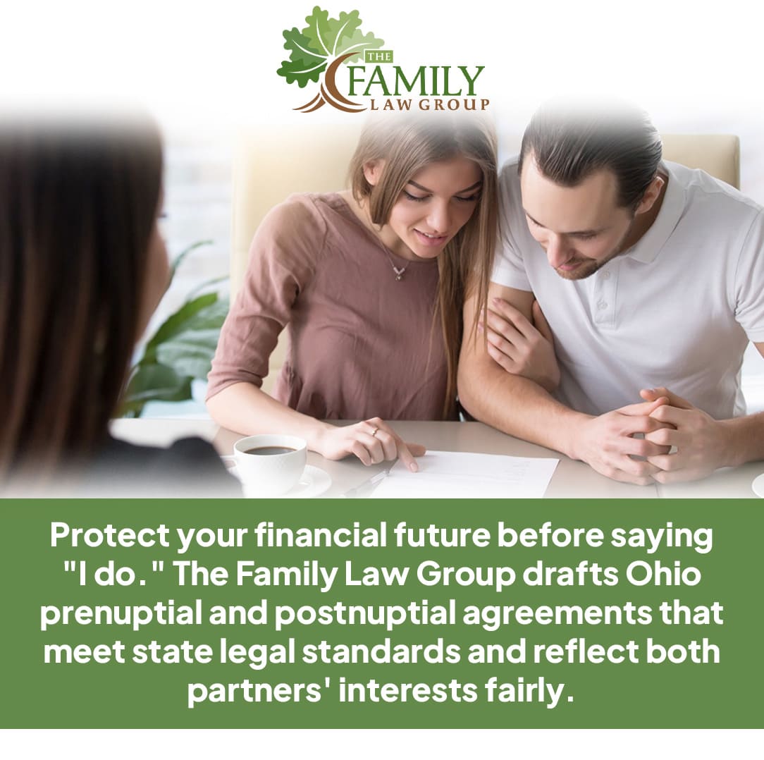 A young couple smiles while reviewing a document with a lawyer or counselor.