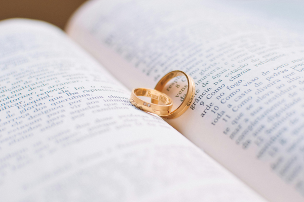 Close up of wedding rings on book.