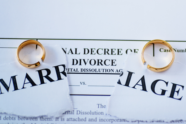 A torn piece of paper with word marriage and two weeding bands.
