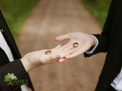 Two people holding wedding rings on the palm of their hands. The Family Law Group logo.