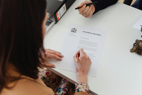 Woman signing divorce papers.
