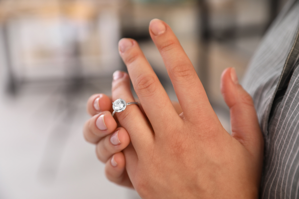 Woman taking of engagement ring.