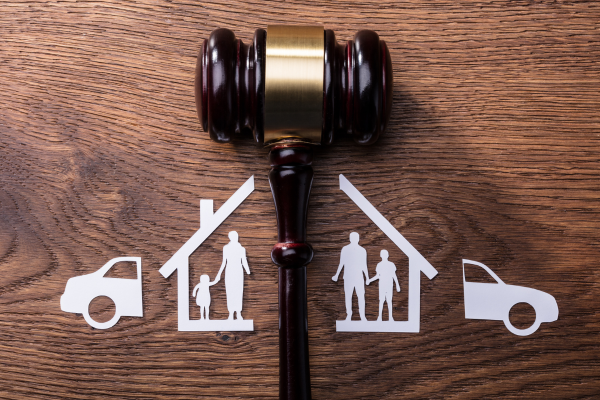 Graphics of family split with gavel on wooden table.